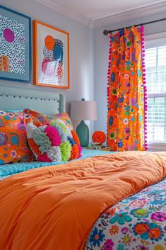 a bedroom with bright colored bedding and pictures on the wall