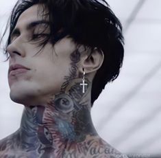 a man with tattoos and piercings on his neck