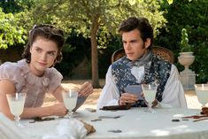 a man and woman sitting at a table with drinks