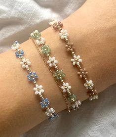 More details: - made out of white, golden, pastel green, blue and brown beads - threaded on nylon - closed with lobster clasps, jump rings 4mm, crimp ends and crimp covers made out of gold plated sterling silver - available in six sizes: 15cm, 16cm, 17cm,  18cm, 20cm and 22cm How to take care: - the material is durable so you can leave it on in water without hesitation Follow my Instagram @florescerjewelry to see some more products and how I make them!  Thanks for your order! Pastel Green Accessories, Green Flower Bracelet, Bohemian Gold Beaded Bracelet With Flower Charm, Green Beaded Jewelry, How To Make Flower Bead Bracelet, Flower Beads Bracelet, Preppy Jewelry, Pretty Jewelry Necklaces, Bracelet Flower