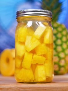 a jar filled with sliced pineapples on top of a wooden table