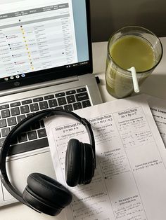 an open laptop computer sitting on top of a desk next to a cup of coffee