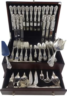 an assortment of silverware in a wooden box with spoons and forks on display