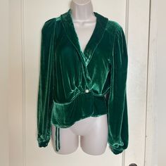 This Sumptuous Green Velvet Wrap Top From Reformation Is New With Tags And Ready To Move In With You! This Long Sleeve Velvet Top Is The Prettiest Emerald Green Color (They Call It "Spruce"), And Features A Collared Plunging Neckline And Gently Puffed Shoulders. It Is A Wrap Style With An Inner Tie And Outer Button Closure As Well As Velvet Covered Button Closures At The Wrists. The Exterior Wrap Closes With A Faux Pearl Button With Silver Tone Rope Pattern Encircling It. The Bottom Portion Is I Elegant Velvet Blouse For Wedding, Elegant Velvet Evening Blouse, Festive Green V-neck Top, Elegant Fitted Velvet Blouse, Chic Fitted Velvet Blouse, Velvet Wrap Top, Green V-neck Formal Blouse, Party Velvet V-neck Top, Peplum Styles