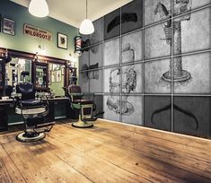 the interior of a barbershop with wood floors and wallpapers on the walls