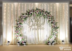 a wedding stage decorated with flowers and greenery