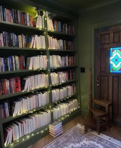 a book shelf filled with lots of books in front of a stained - glass window