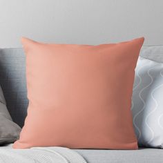 a peach colored pillow on a gray couch