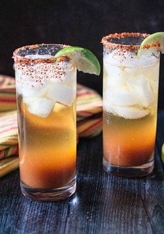 two glasses filled with drinks sitting on top of a table