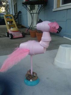 a pink horse made out of toilet paper on top of a blue base and some rocks