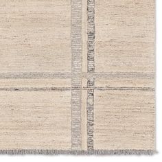 an area rug with four squares and fringes on the bottom, in neutral colors