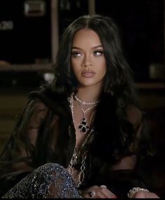 a woman with long black hair sitting down