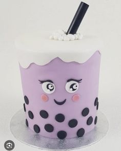 a purple cake with black polka dots and a straw sticking out of it's top