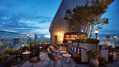 an outdoor dining area overlooking the city at night