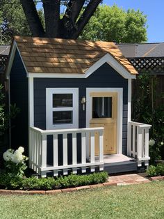 a small blue and white house with a brown roof