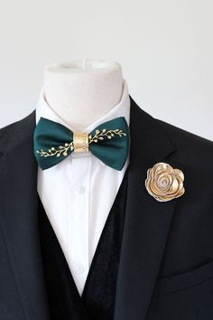 a man in a tuxedo with a green bow tie and gold brooch