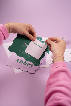 a person cutting out some paper on top of a purple surface with scissors and tape