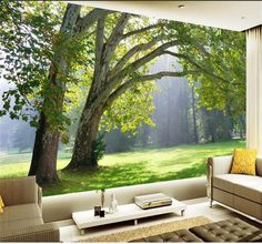 a living room filled with furniture next to a large window covered in green grass and trees