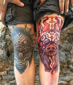 two men with tattoos on their legs, one has a demon and the other has a cross