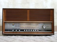 an old radio sitting on top of a white rug