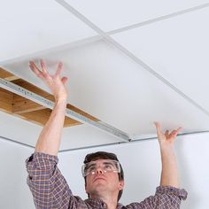 a man in glasses is fixing the ceiling