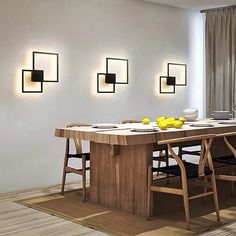 a dining room table with chairs and lights on the wall