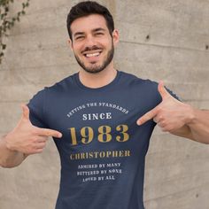 a man wearing a t - shirt with his thumbs up