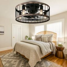 a bed room with a neatly made bed and a large fan hanging from the ceiling