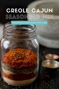 a glass jar filled with seasoning mix on top of a wooden table