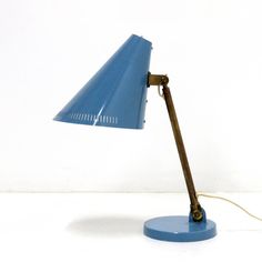 a blue desk lamp sitting on top of a white table