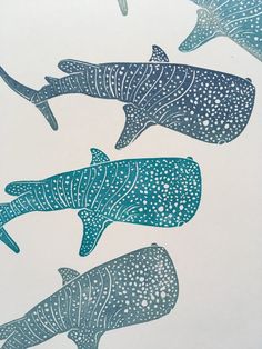 three whale's are swimming in the ocean with blue and white designs on them