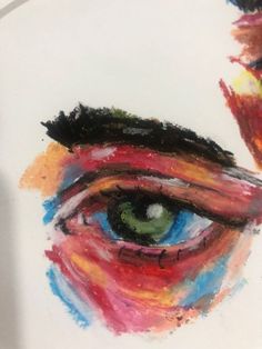 an eye painted with multicolored paint on a white surface next to a drawing of a man's face