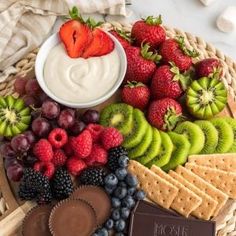 a platter filled with fruit, crackers, and chocolates on top of a table