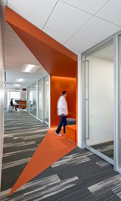 a man walking through an orange and white office