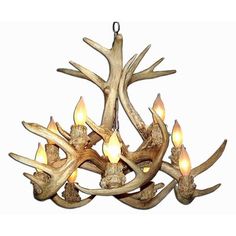 a chandelier with antlers hanging from it's sides and lit candles in the middle