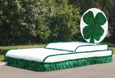 a bed made out of grass with a four leaf clover on top and a green tinsel