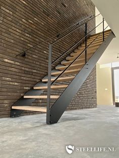 a metal stair case next to a brick wall