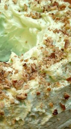 a cake with green frosting and walnuts on top