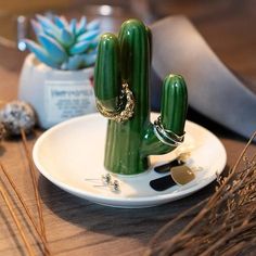 a green cactus sitting on top of a white plate