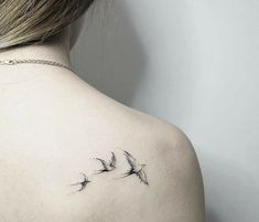 the back of a woman's shoulder with two birds on it