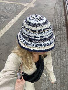 a woman walking down the street with a hat on