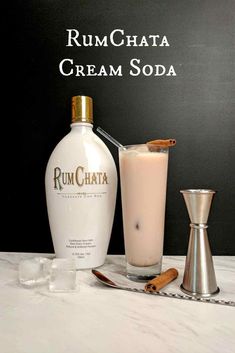 a bottle of rumchata cream soda next to a shaker and cinnamon sticks