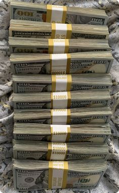 stacks of one hundred dollar bills are stacked on top of each other with gold ribbons