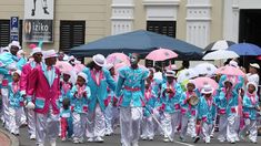 a large group of people walking down the street with umbrellas in their hands,