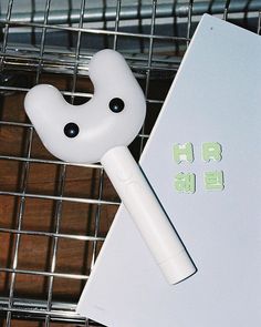 a white object sitting on top of a table next to a pen