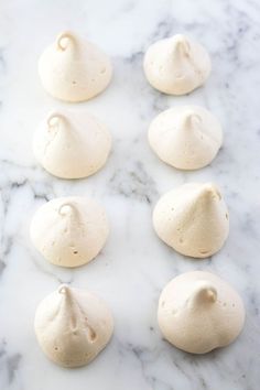 six uncooked doughnuts sitting on top of a white marble countertop