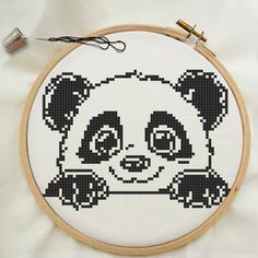 a panda bear cross stitched in black and white