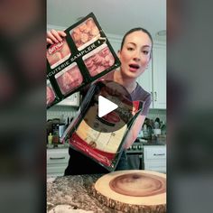 a woman holding two packages of food on top of a counter