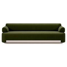 a green couch sitting on top of a white table