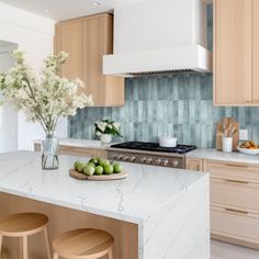 a kitchen with marble counter tops and wooden stools in front of the stove top